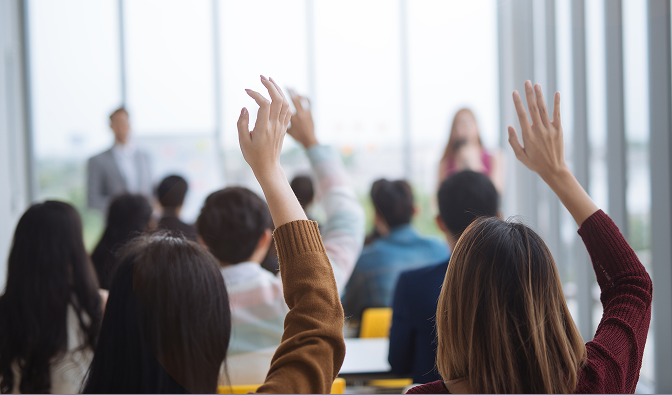 Students raising their hands in a classroom