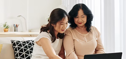 A parent and teenager learning together on a laptop